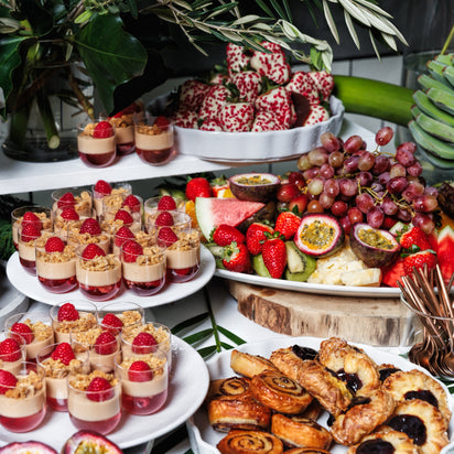 Assorted pastries, fruits, and desserts on a buffet table