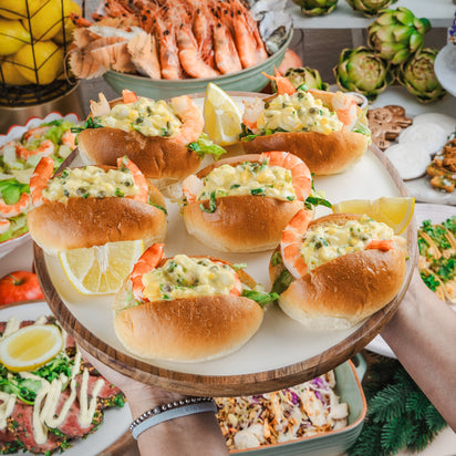 Assorted seafood and vegetable dishes on a table with a focus on seafood rolls.