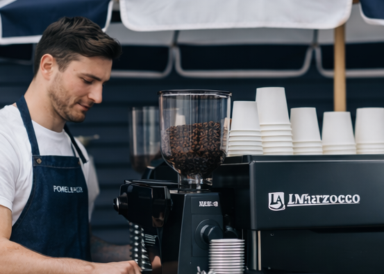 Barista preparing coffee at a Pomelo & Co coffee cart