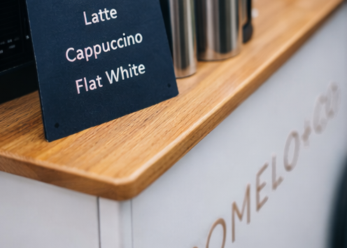 Coffee menu sign for lattes, cappuccinos and flat whites on a Pomelo & Co coffee cart